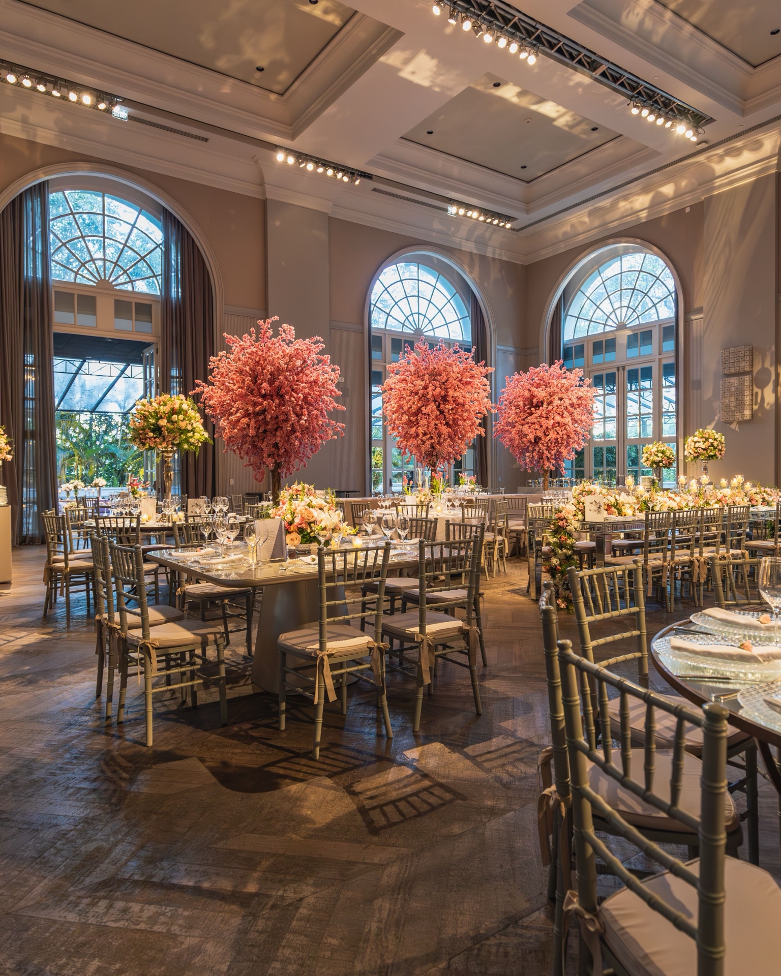 A grand hall set for an evening event with floral centrepieces
