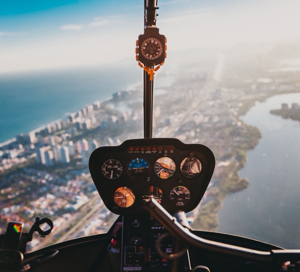 A view from a helicopter cockpit over a coastal city