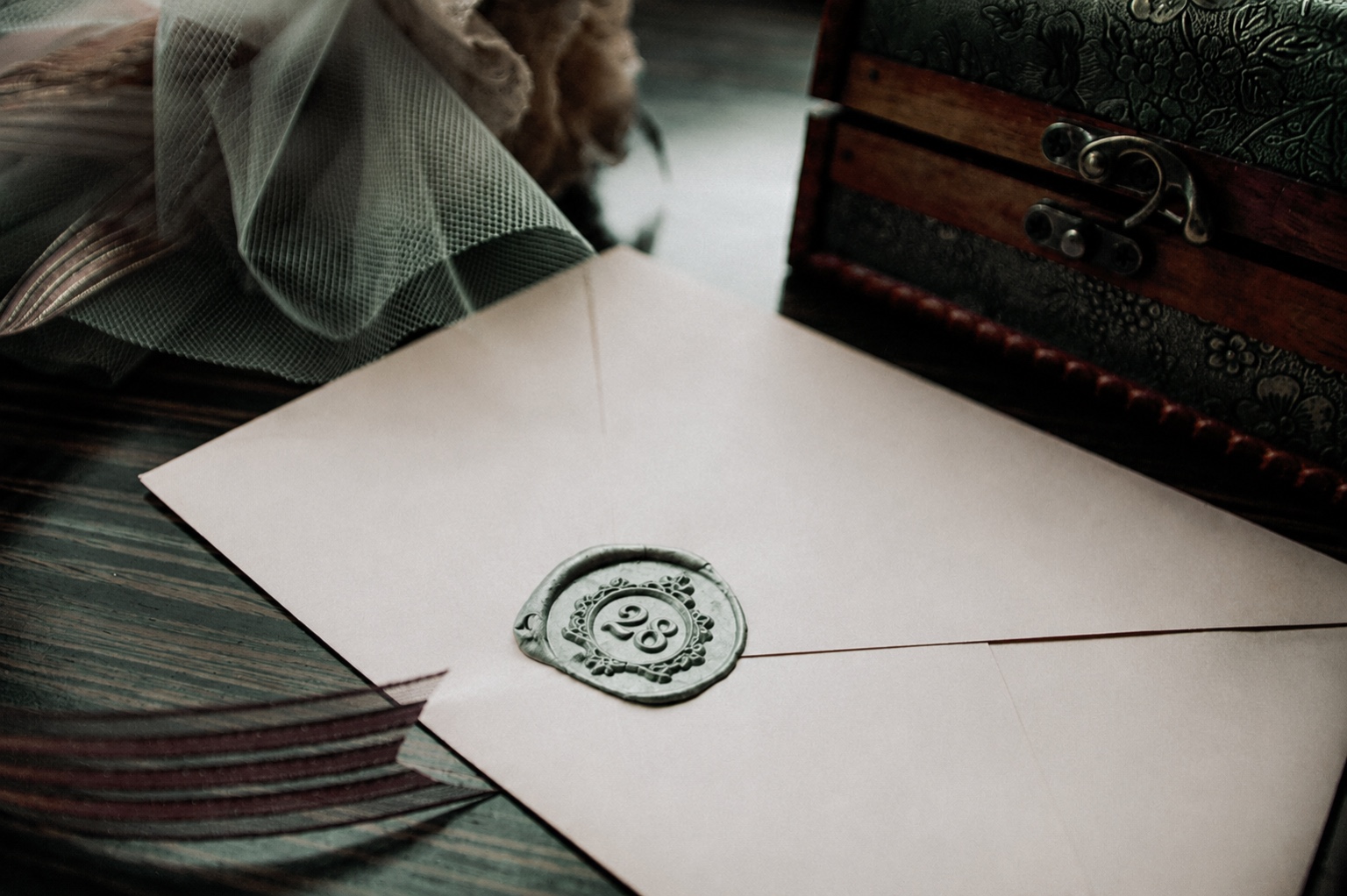 A wax seal stamped with '28' on an envelope